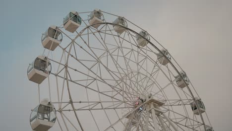 ferris wheel with empty cabins against a cloudy sky, evoking serenity and nostalgia