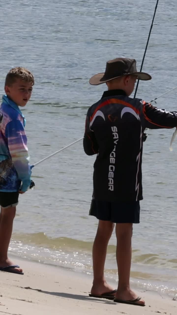 두 소년이 이 많은 해변에서 함께 시를 하고 있다