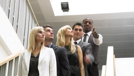 Gente-De-Negocios-En-Fila-En-Las-Escaleras-Con-Los-Pulgares-Hacia-Arriba-Sonriendo-A-La-Cámara