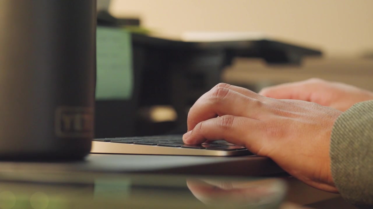 Hands of a man typing on a keyboard in the office