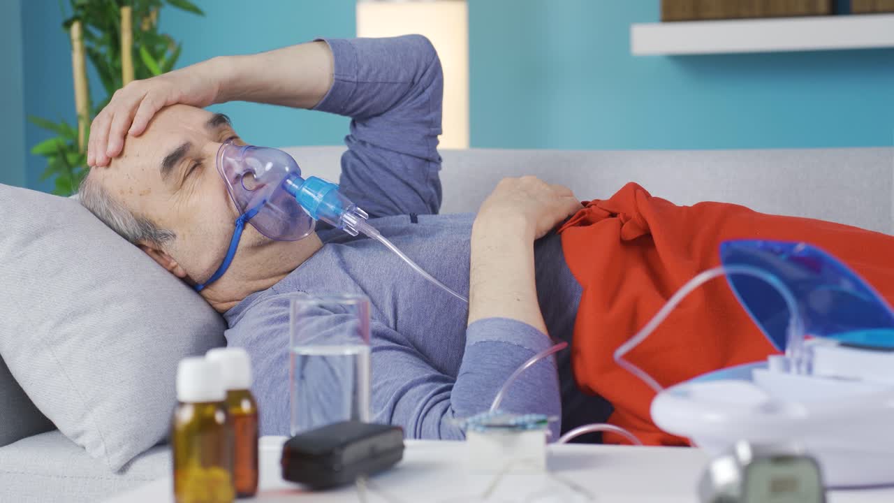 人工呼吸器を装着し、無力に横たわる高齢男性。