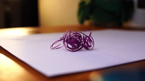 un pequeño paquete de hermosas cuerdas de colores se coloca sobre un escritorio y se retira de nuevo