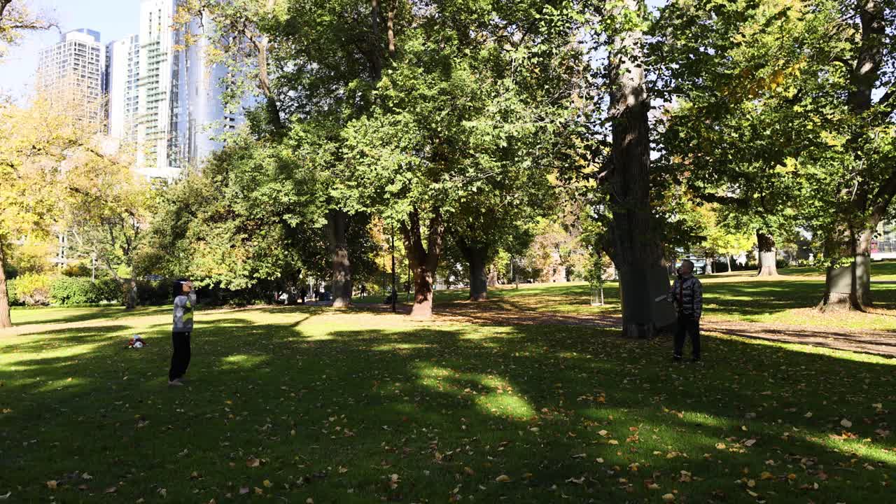 dos personas jugando al bádminton en un parque
