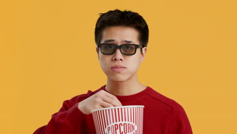 young man watching a movie with popcorn