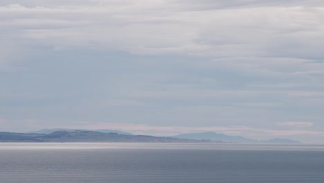 Beautiful-New-Zealand-landscape-with-ocean-and-distant-mountain