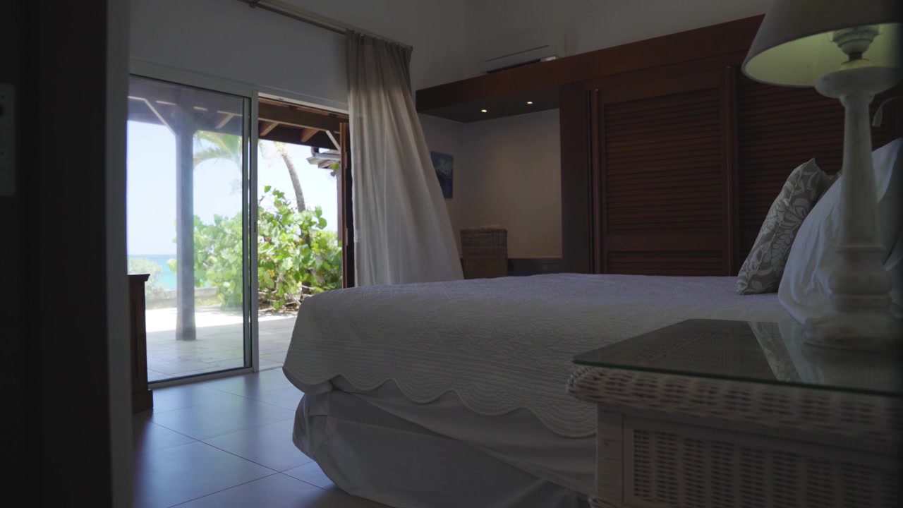 entering hotel room with wind breeze moving balcony curtains and nature garden view