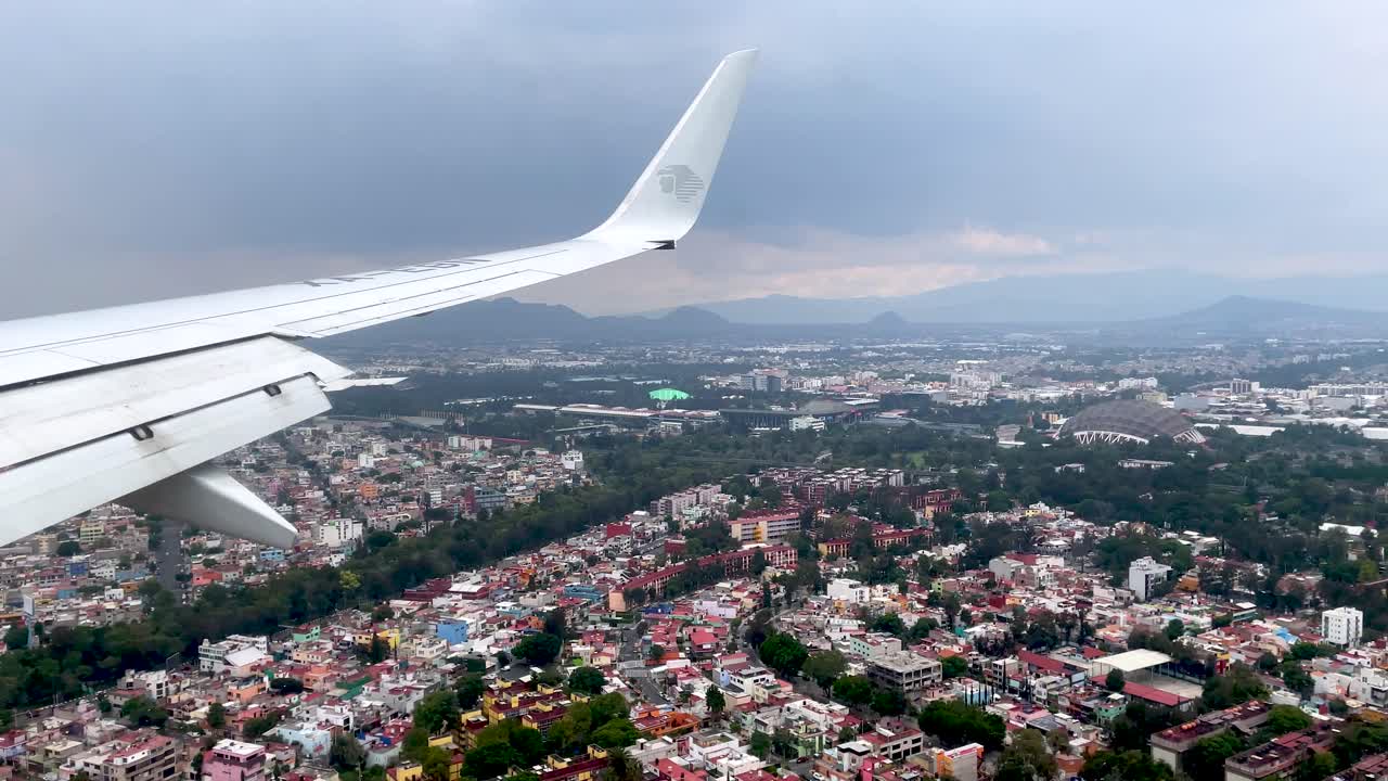 tiro desde la ventana del avión durante el aterrizaje en la ciudad de méxico viendo el palacio de deportes