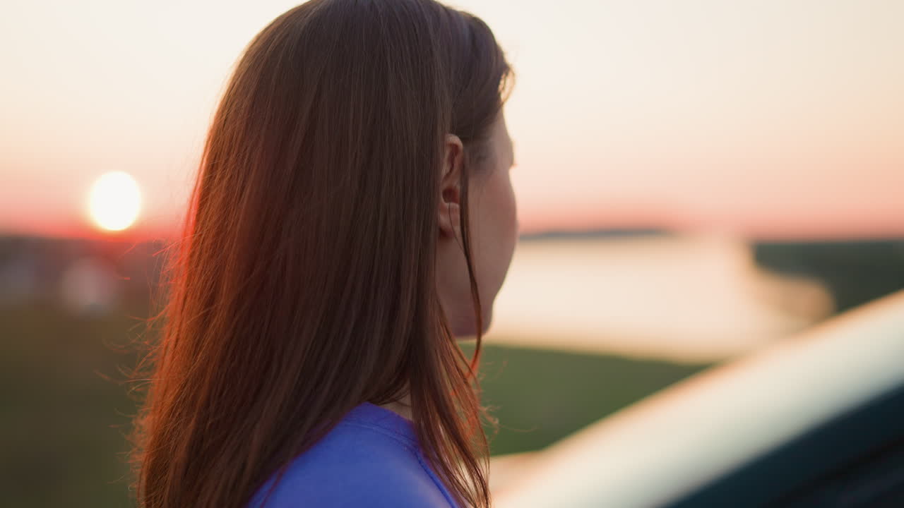 mujer mira el río de cerca mujer tranquila con el cabello marrón suelto contemplar la orilla del río en