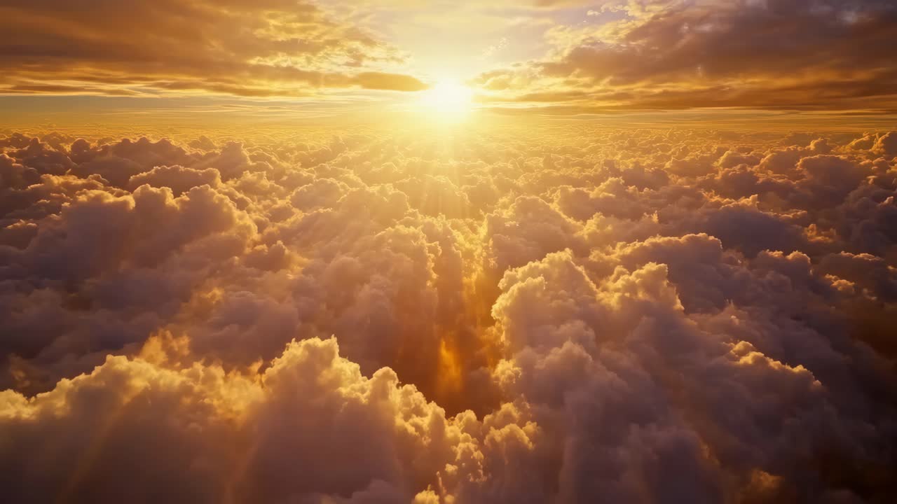 Aerial video of a stunning sunset above fluffy clouds, capturing the golden light and vast sky