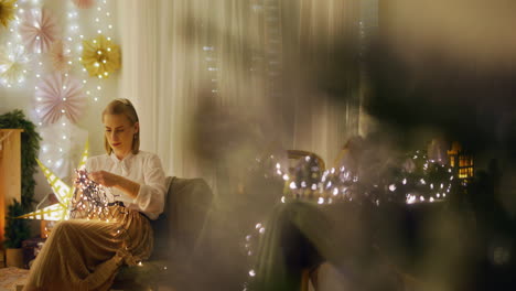 mujer desenredando luces de navidad en la acogedora sala de estar