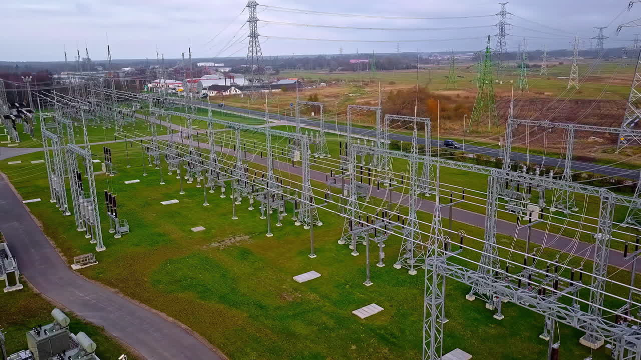 Huge electrical substation in a field feeds power to the grid - aerial parallax view
