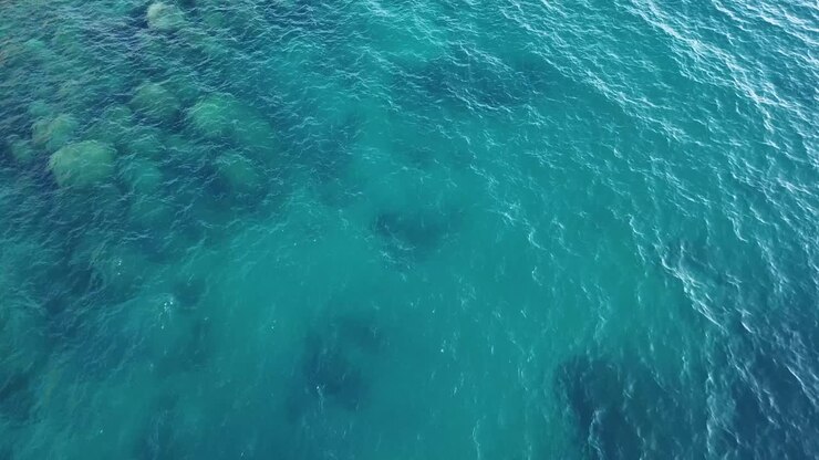Veduta aerea a volo d'uccello di acqua cristallina di un lago alpino.