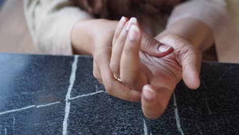 woman's hands resting on a table