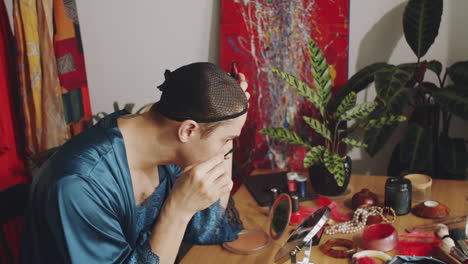 transgender man applying mascara