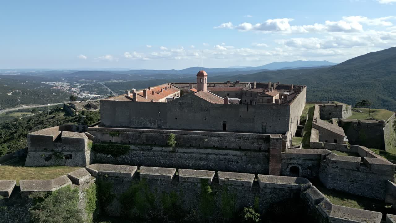 Ripresa aerea della fortificazione bastione Fort de Bellegarde nelle verdi e lussureggianti montagne dei Pirenei, Francia meridionale.