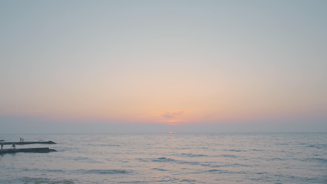 Sunset over the Ocean with People on the Pier
