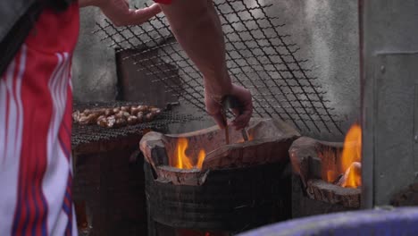 vendor adjusting barbecue coals