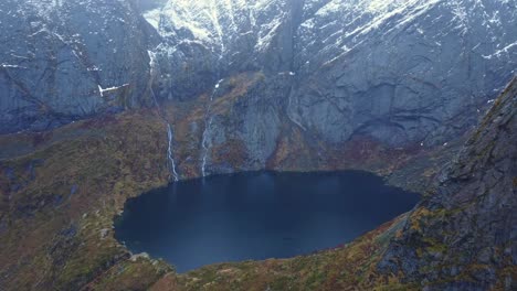 lago de cráter rodeado de enormes montañas rocosas en noruega