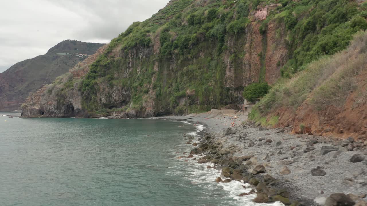 aislada playa de guijarros de basalto praia dos anjos con lugareños relajándose en la orilla