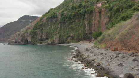 Secluded-basalt-pebbles-beach-Praia-dos-Anjos-with-locals-relaxing-on-shore