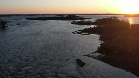 Aerial-shot-of-the-salt-marsh-or-wetlands,-epic-drone-shot-into-the-sun