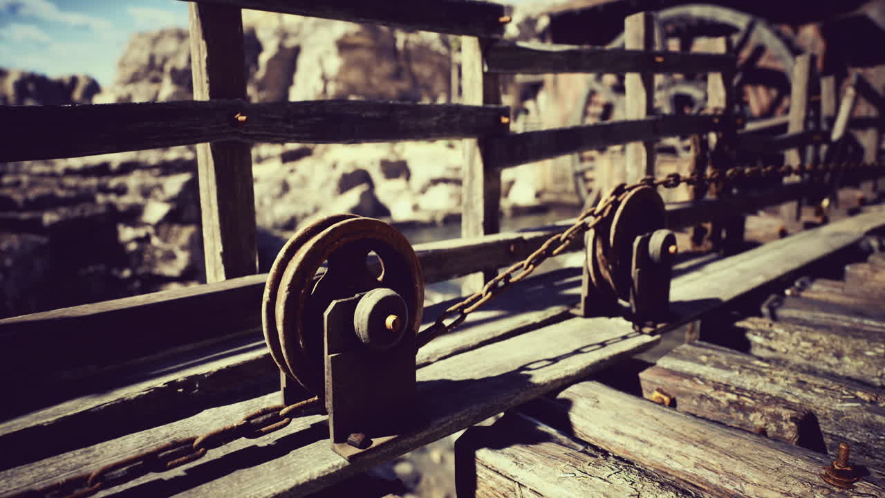 Rustic pulley system on a wooden bridge in a natural landscape