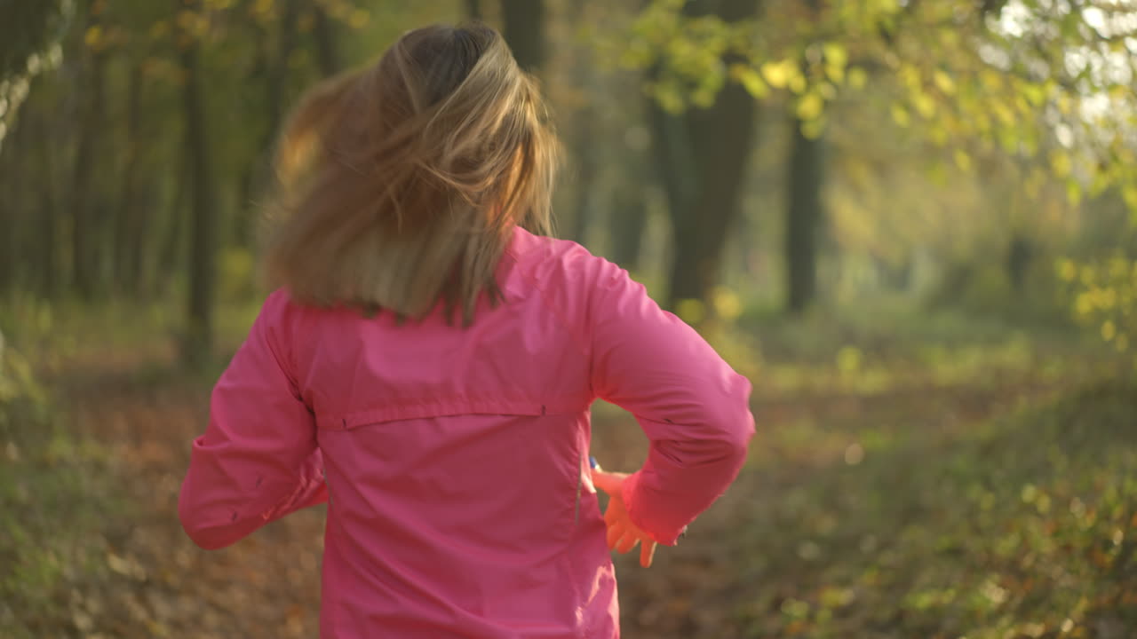 mujer corriendo en un parque de otoño