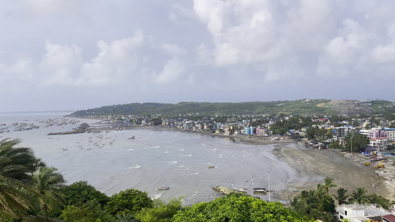 Aerial drone view of Uttan Beach in Mumbai with a cloudy sky, lush trees and the cityscape in the background Maharashtra 4K