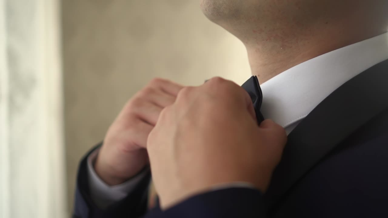 el hombre ajusta el cuello y la pajarita.