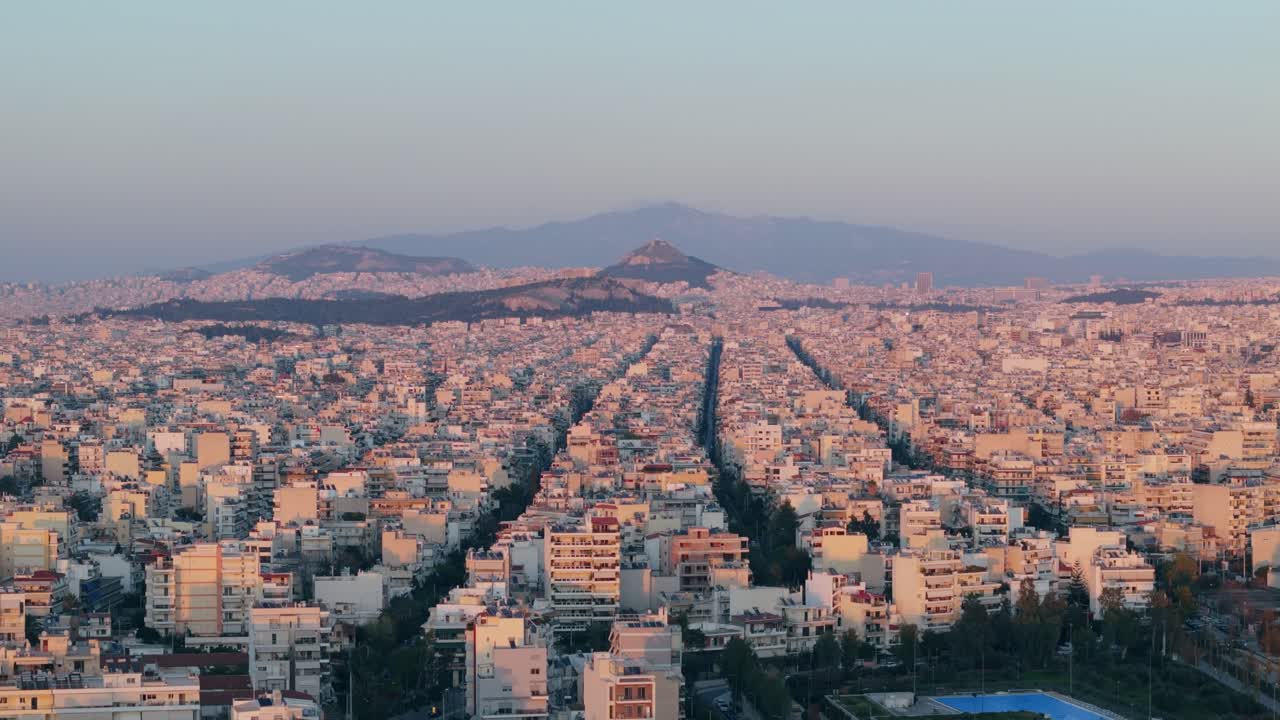 그리스의 수도 아테네의 공중 사진, 해가 지는 시내 풍경 위의 드론