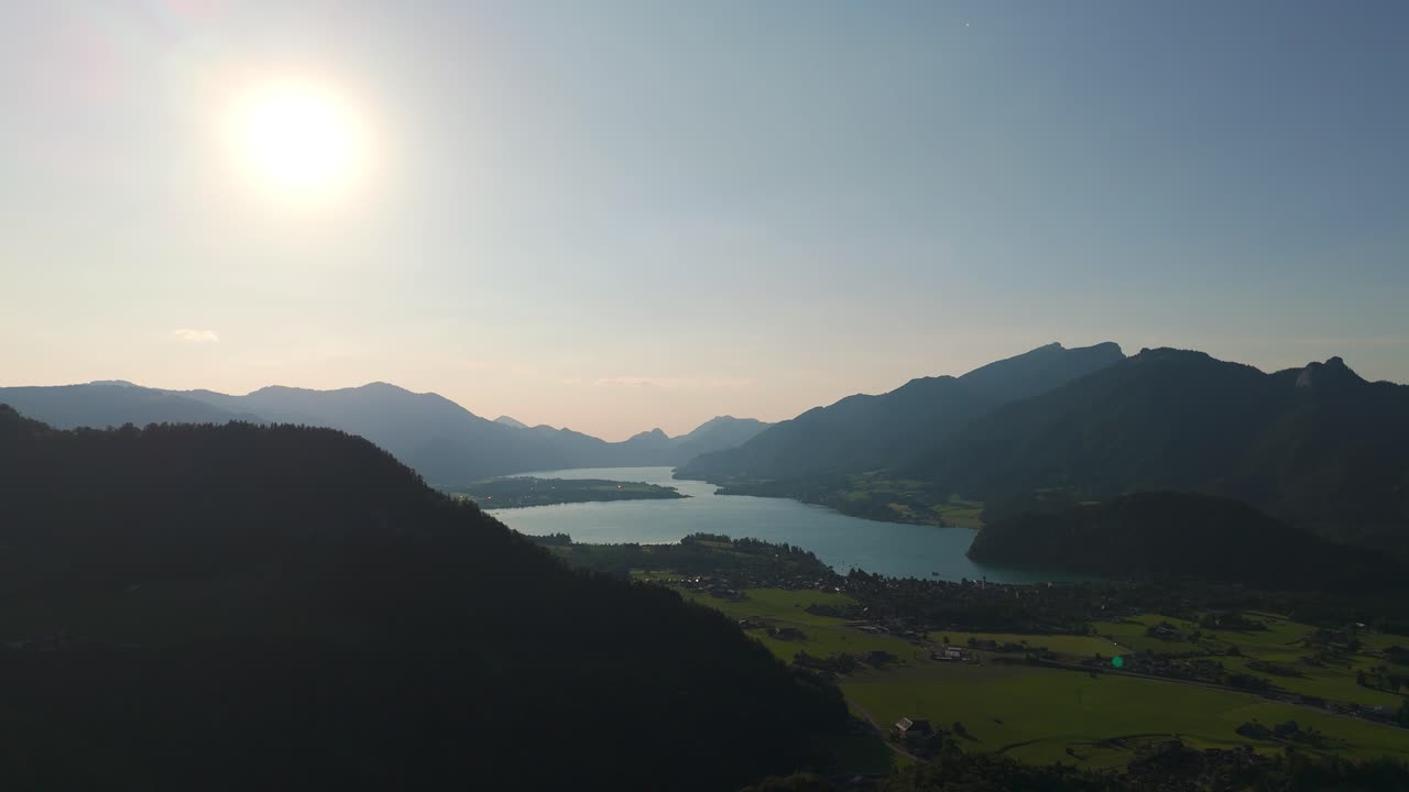 Aerial static fly pristine lake under sunlight landscape, Alps in Late Afternoon Light, Drone fly in Austria, Wolfgangsee waters