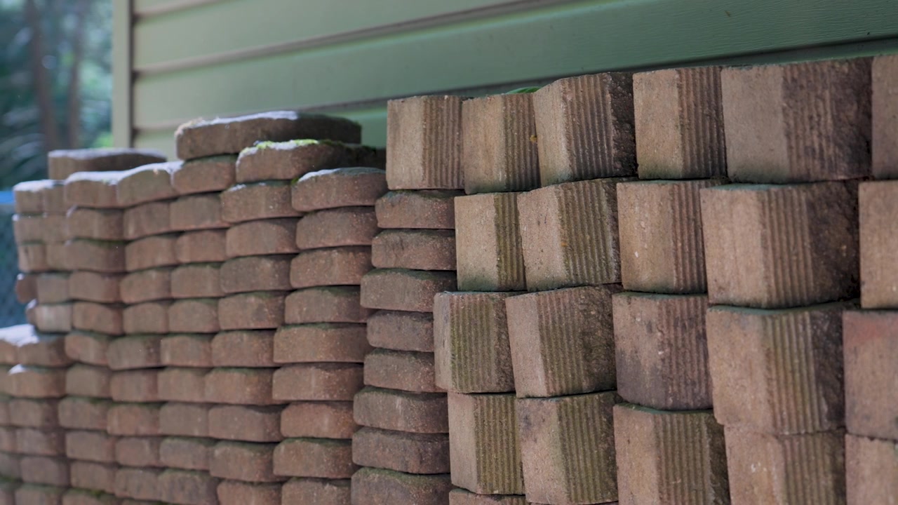 A stack of bricks used for a retaining wall, panning left.