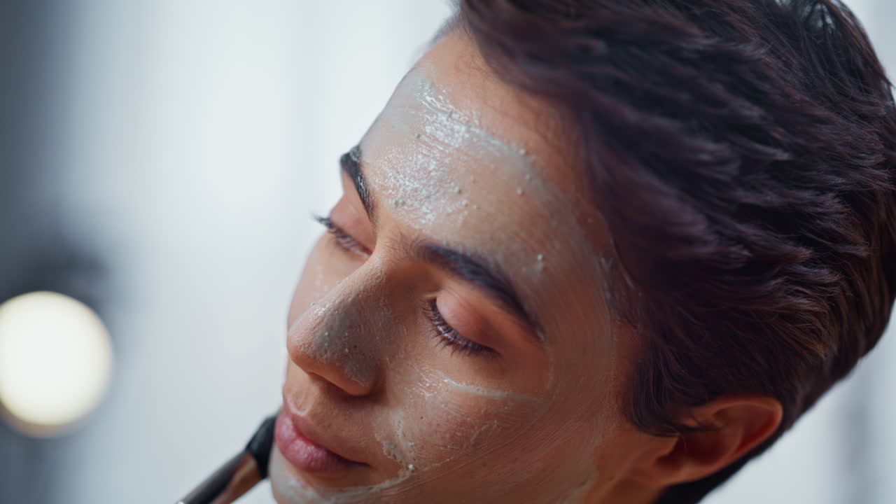 Shorthaired model applying face mask in bathroom portrait. Lady morning routine