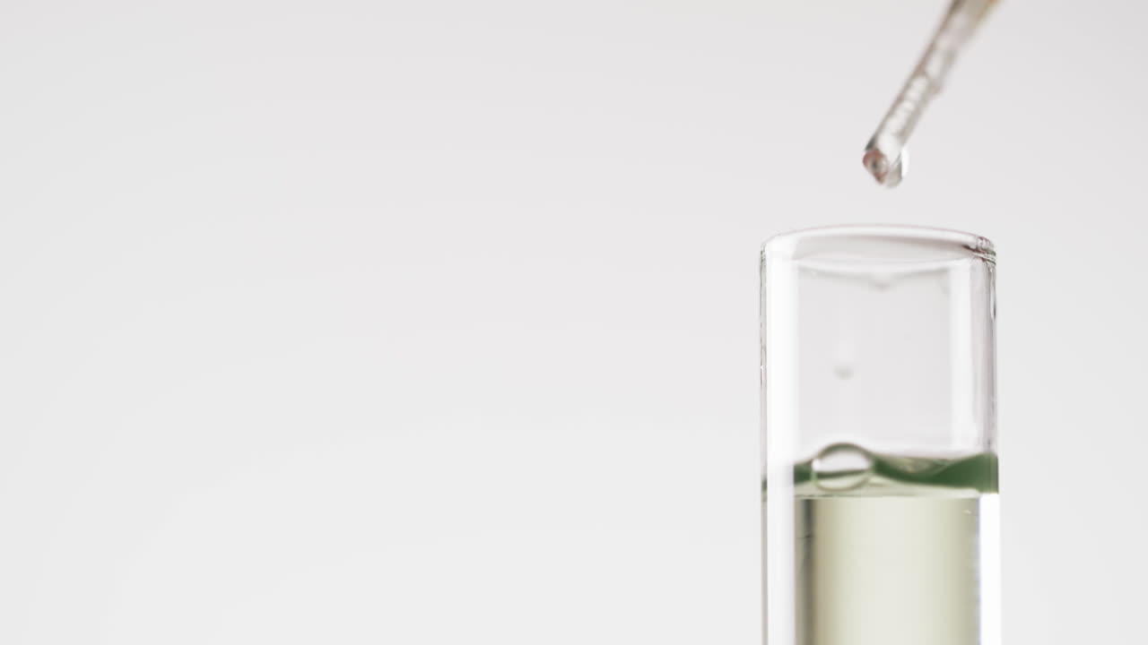 vídeo de primer plano de la pipeta y el tubo de ensayo y espacio de copia sobre fondo blanco