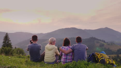 Un-Grupo-De-Amigos-Juntos-Admiran-El-Hermoso-Paisaje-De-Montaña,-Toman-Fotos-De-Viaje-Y-Se-Activan