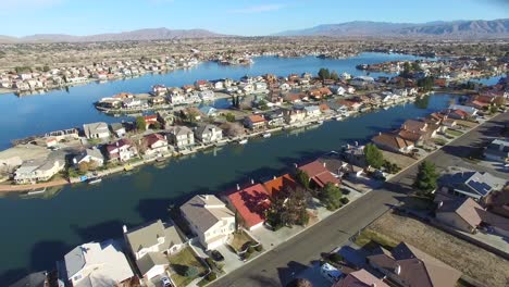 Antena-Sobre-Un-Barrio-Suburbano-En-El-Desierto-Con-Un-Lago-Artificial-Distante-1