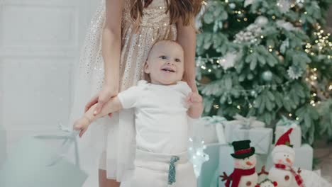 portrait of smiling baby boy dancing with present box in modern house.