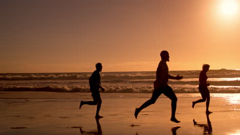 people running on the beach at sunset