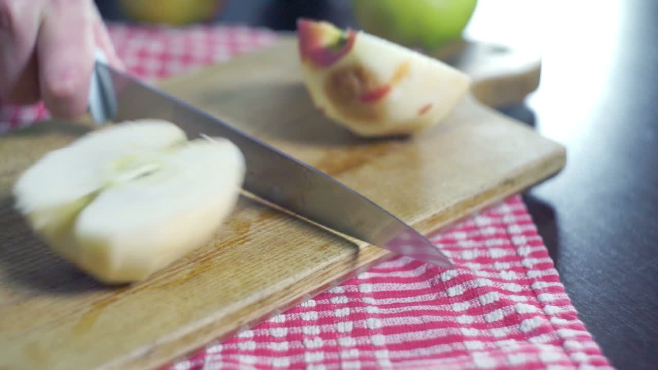 chef cortando manzana pelada en un tablón de madera en la cocina. rebanada de manzana