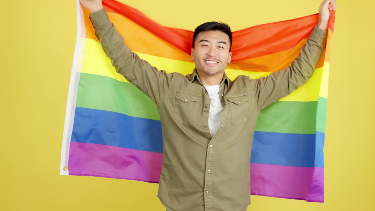 Man holding a rainbow pride flag