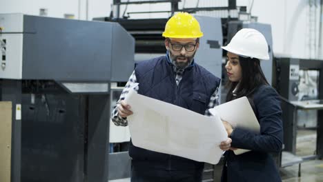 Vista-Frontal-De-Los-Trabajadores-De-La-Imprenta-Inspeccionando-La-Calidad-De-La-Impresión.