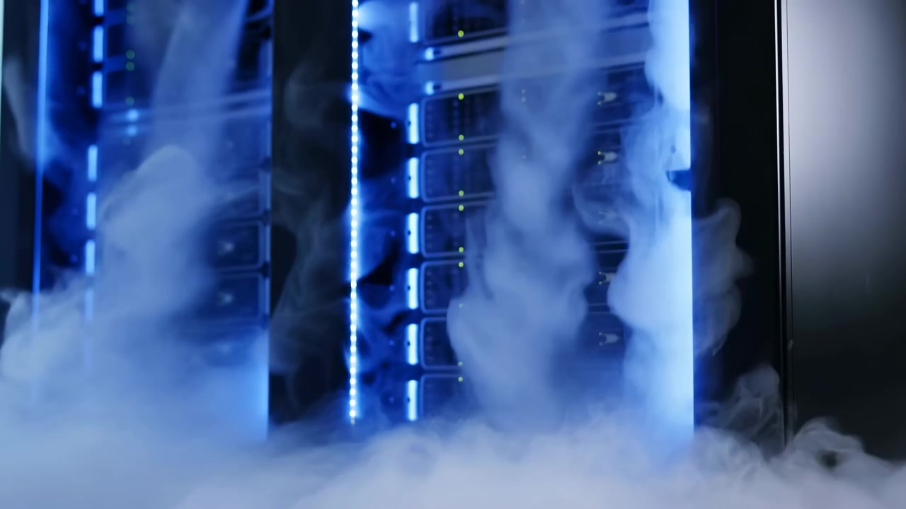 Thick white vapor rolls through a dim server room, curling around rows of rack-mounted equipment as blue light strips and tiny status indicators glow through shifting haze.