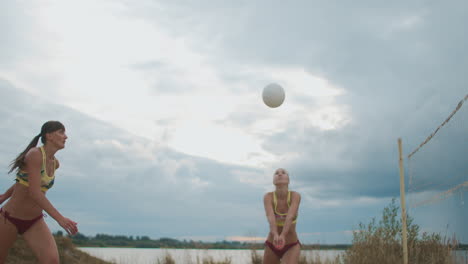 two professional beach volleyball player women are attacking other team on open sand court slow motion shot of movements