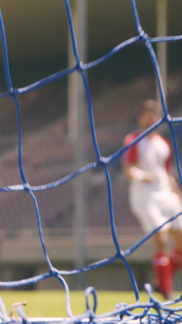 футболист забивает гол.