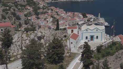Cinematic telephoto drone of Symi churches, revealing Symi’s colorful architecture