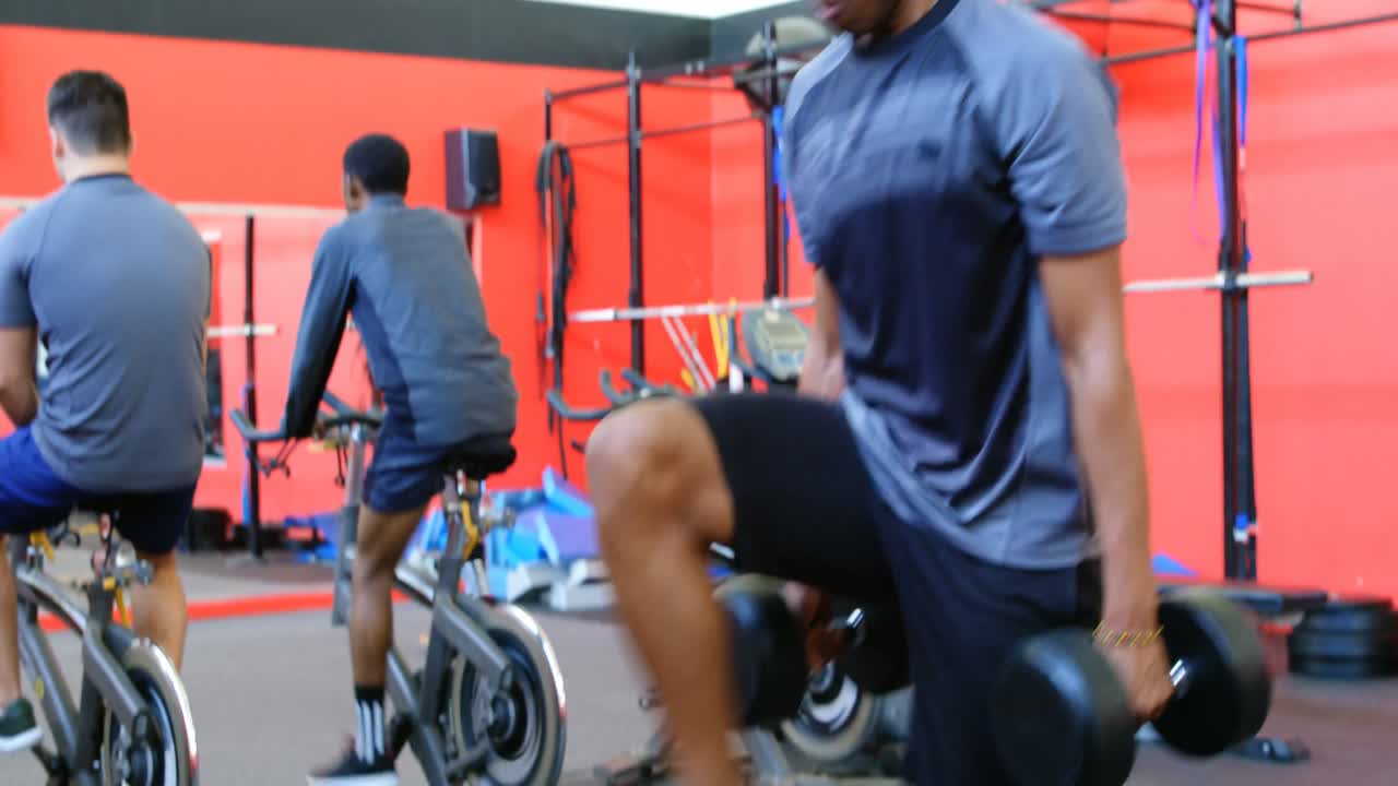 체육관 4k에서 덤벨로 운동하는 운동 선수