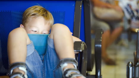 little boy using touchpad in waiting room