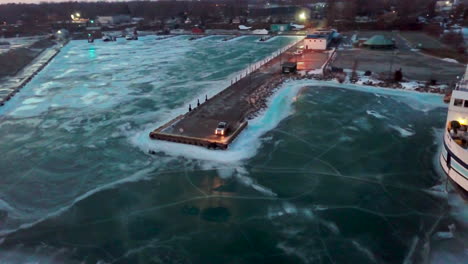 A-pickup-truck-sitting-at-the-end-of-a-dock-with-the-headlights-reflecting-on-the-frozen-lake-during-winter-in-Canada-at-sunset