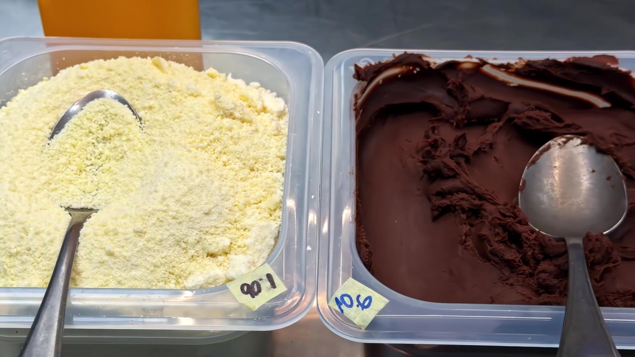 Topping per gelato in vaschette di plastica con cioccolato, cereali e salse dolci esposte per la mescita