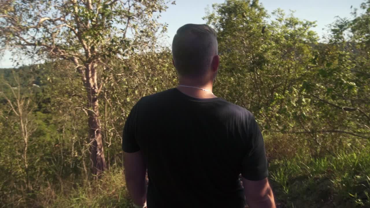 slow motion following man walking downhill.